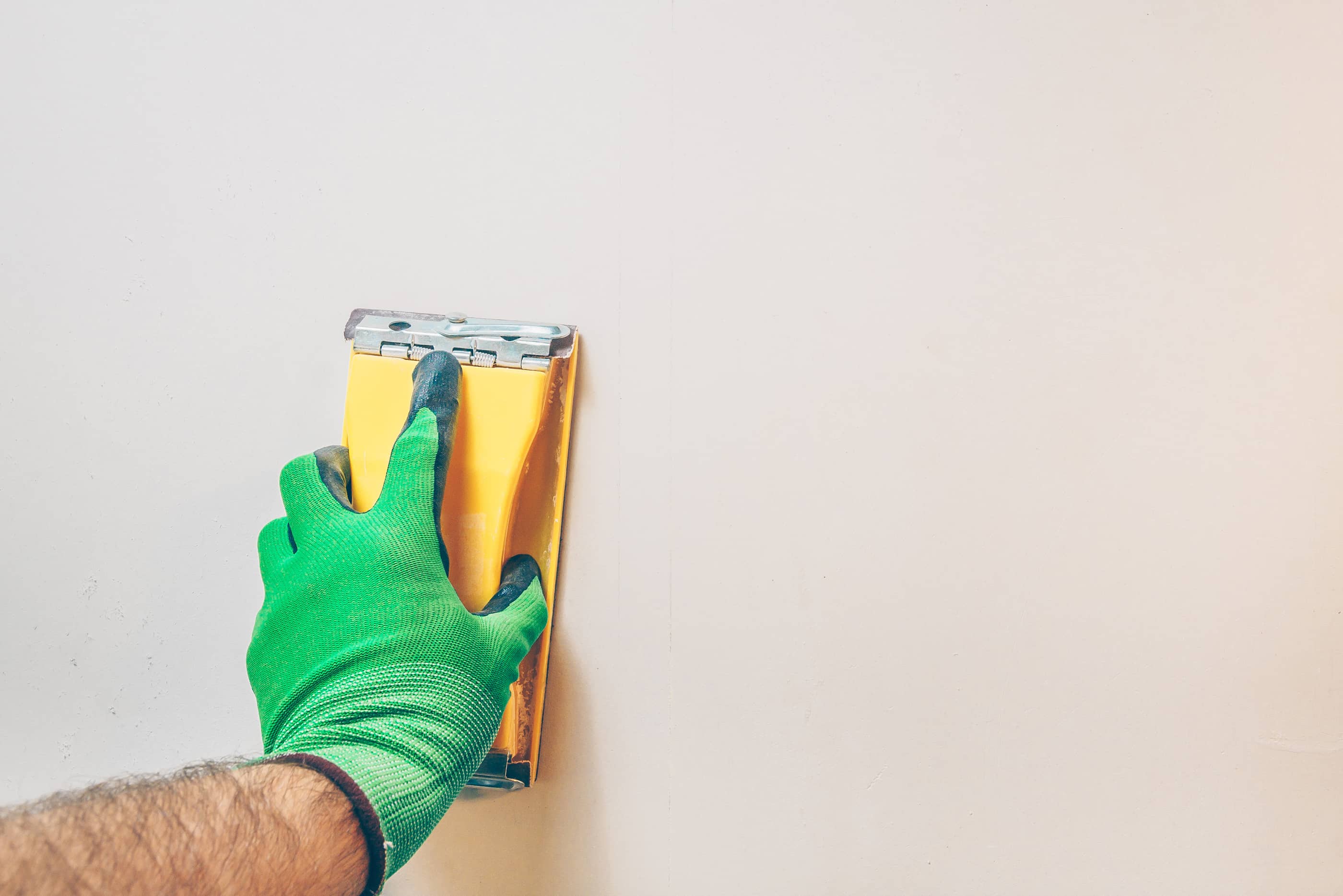 Sand any excess plaster off the wall until matching smoothness with the rest of the wall