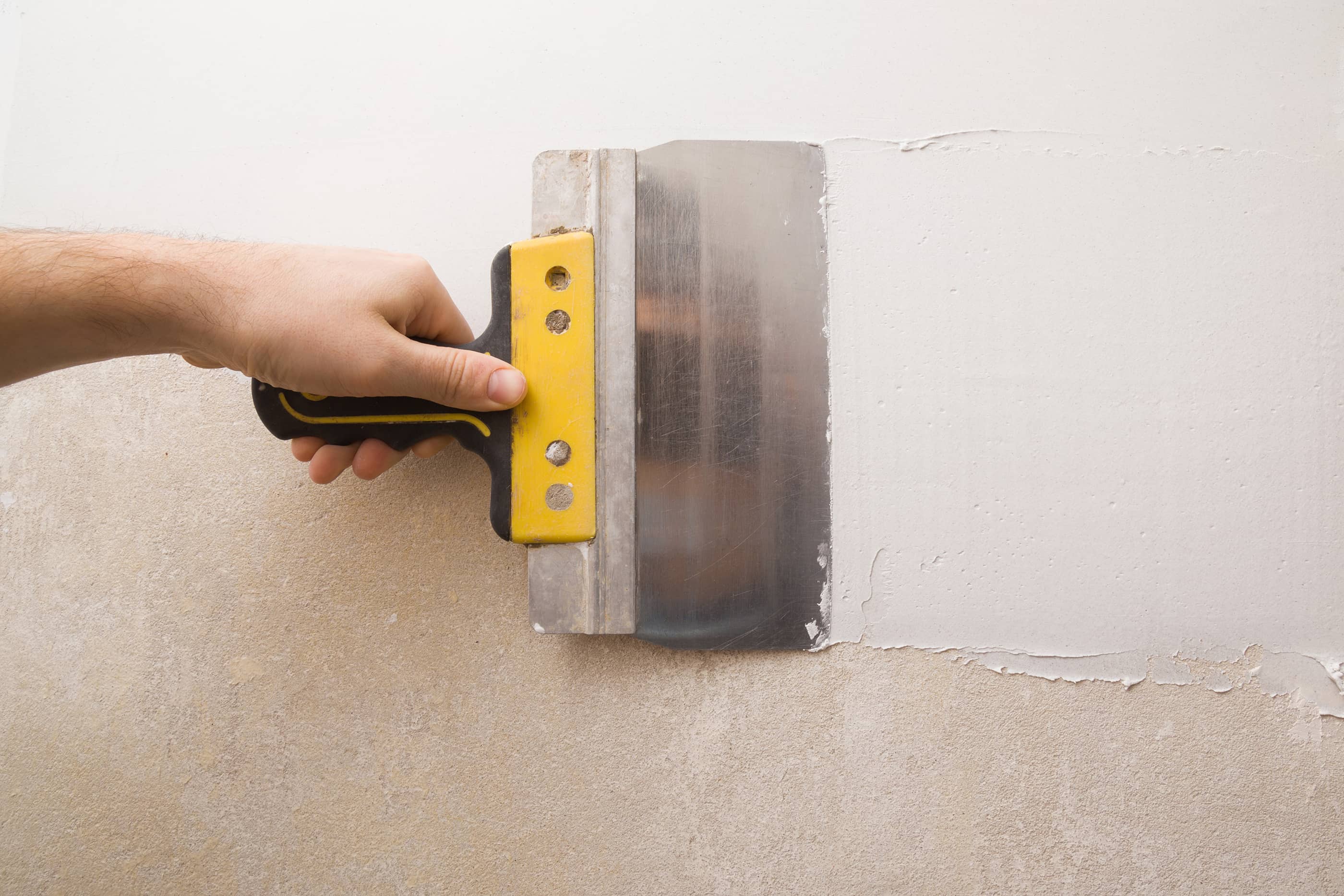  Use the putty knife to apply drywall plaster over the new piece of drywall, including the mesh tape