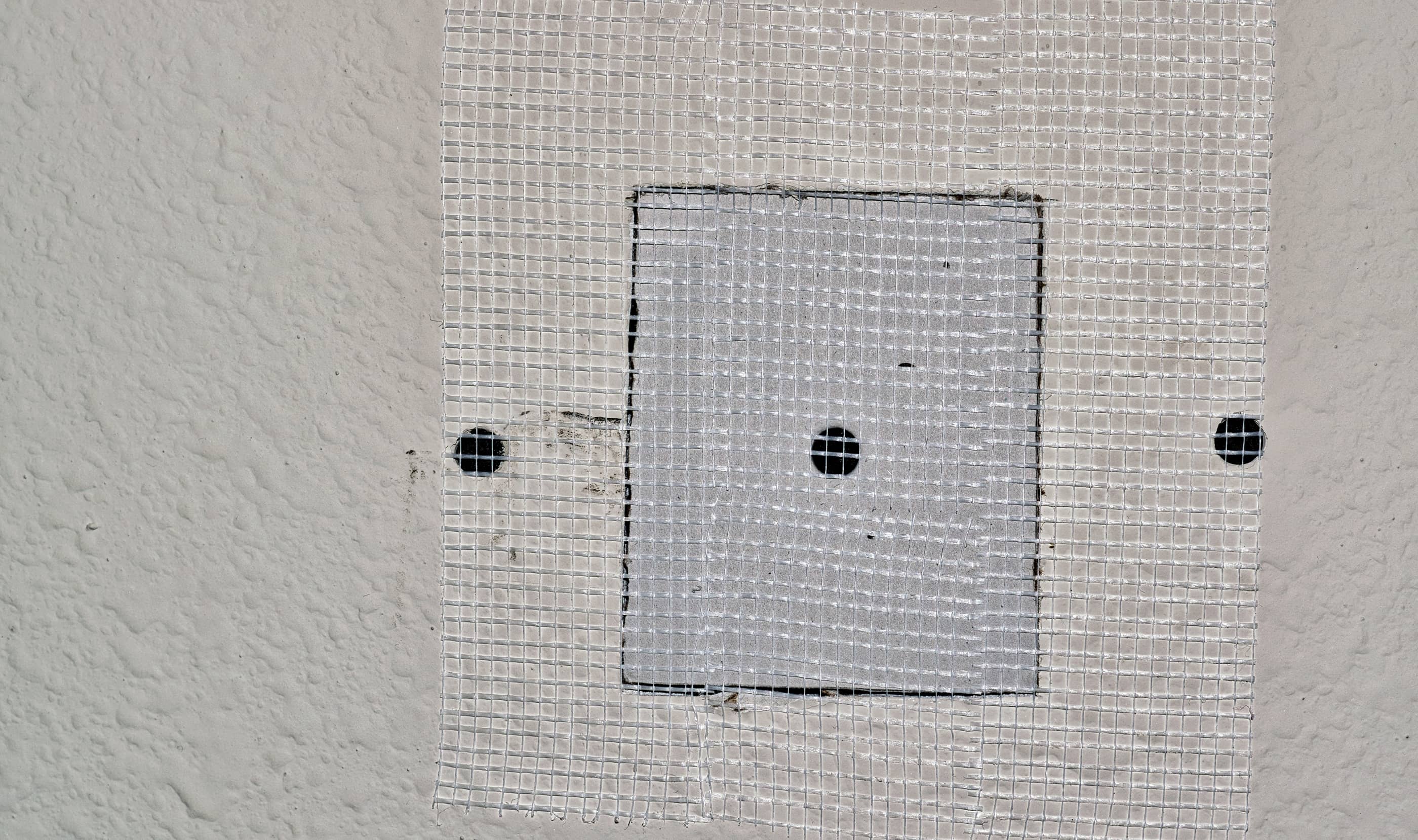 Take the plaster mesh tape and place it along the edge of the new drywall piece to help you create a seamless edge.